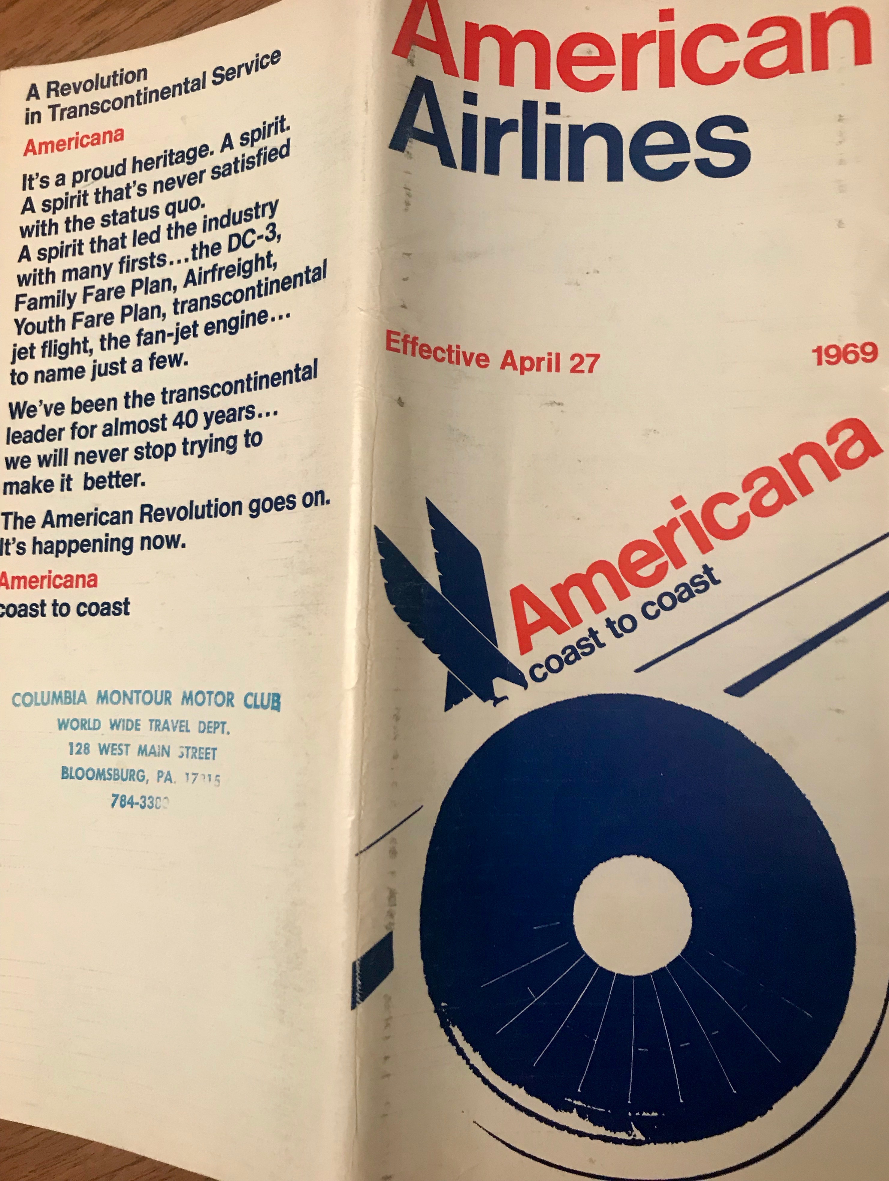 This is the front of an airline timetable booklet from American Airlines which was produced in 1969.  The print is bright blue and red in retro fonts and American's old logo with an eagle is also present. 