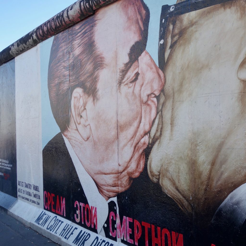 Part of the Berlin Wall with a famous mural depicting Reagan and Mikhail Gorbachev kissing