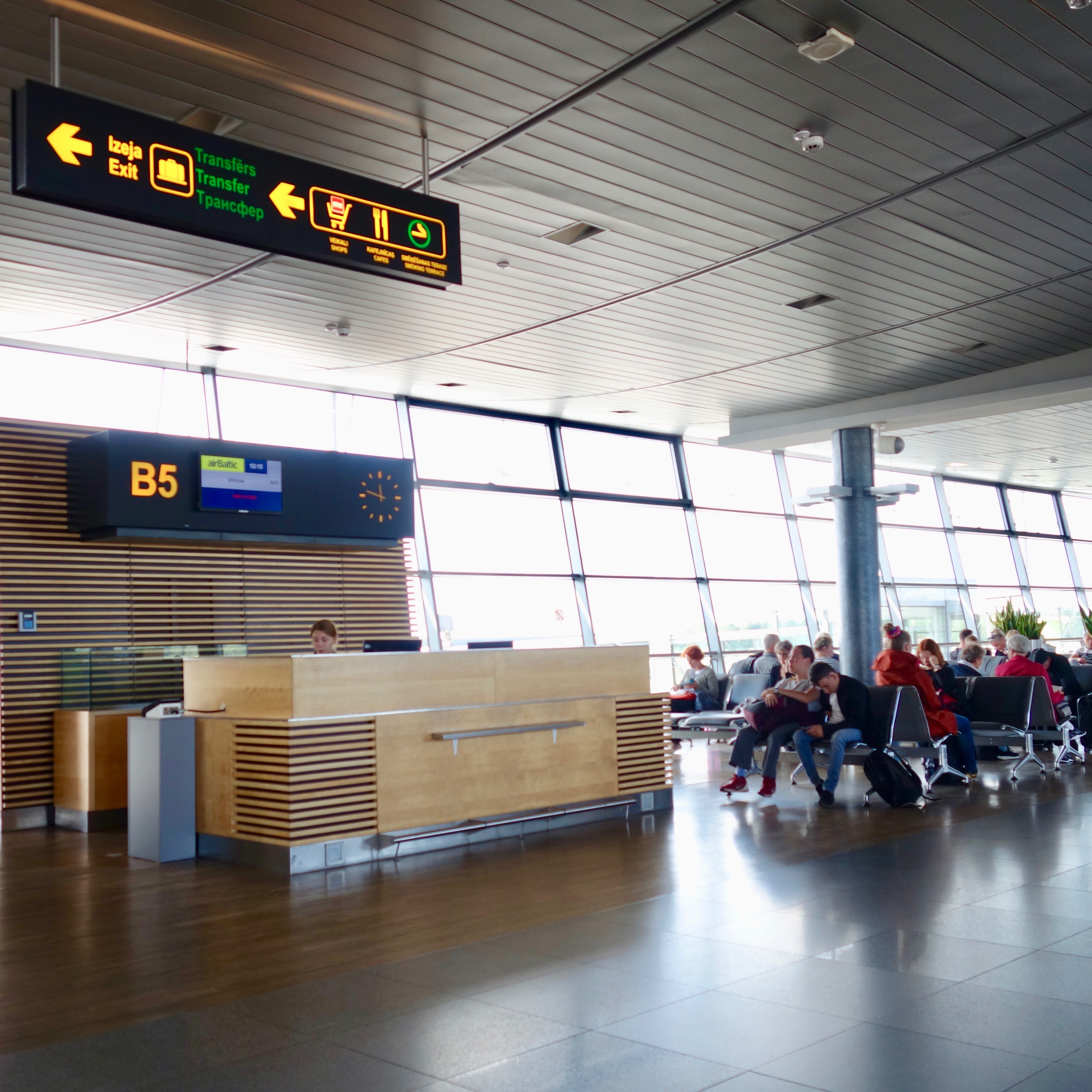 Sleek new gate podium at Riga airport in Latvia.  airBaltic operates their hub here and the blond colored slats that form the podium create a modern look and feel.  A wall of glass allows in abundance of light as passengers wait in seating near the gate.  