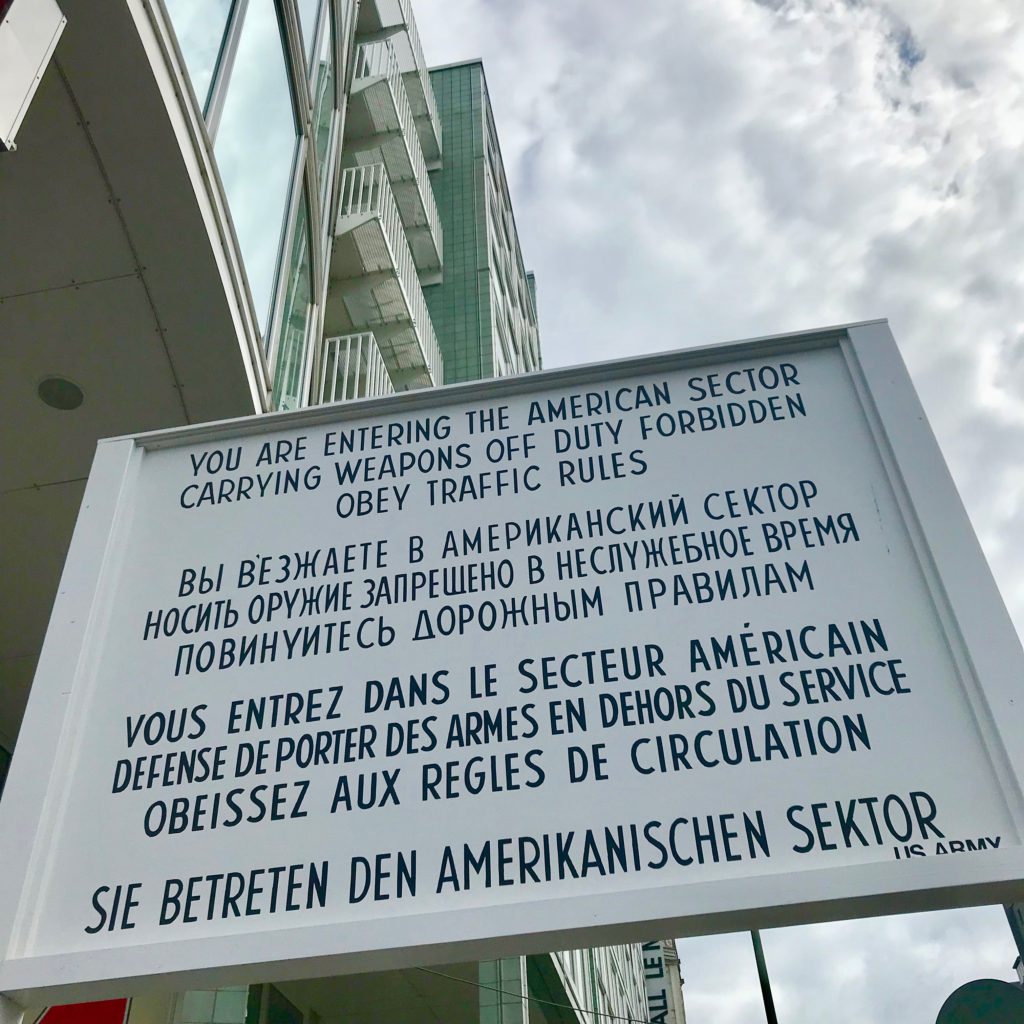 Checkpoint Charlie is an important item on the top ten ways to honor history while visiting Berlin.  Historical sign posted at Checkpoint Charlie in English, Russian, French and German explaining the transition between the Russian and American sector.