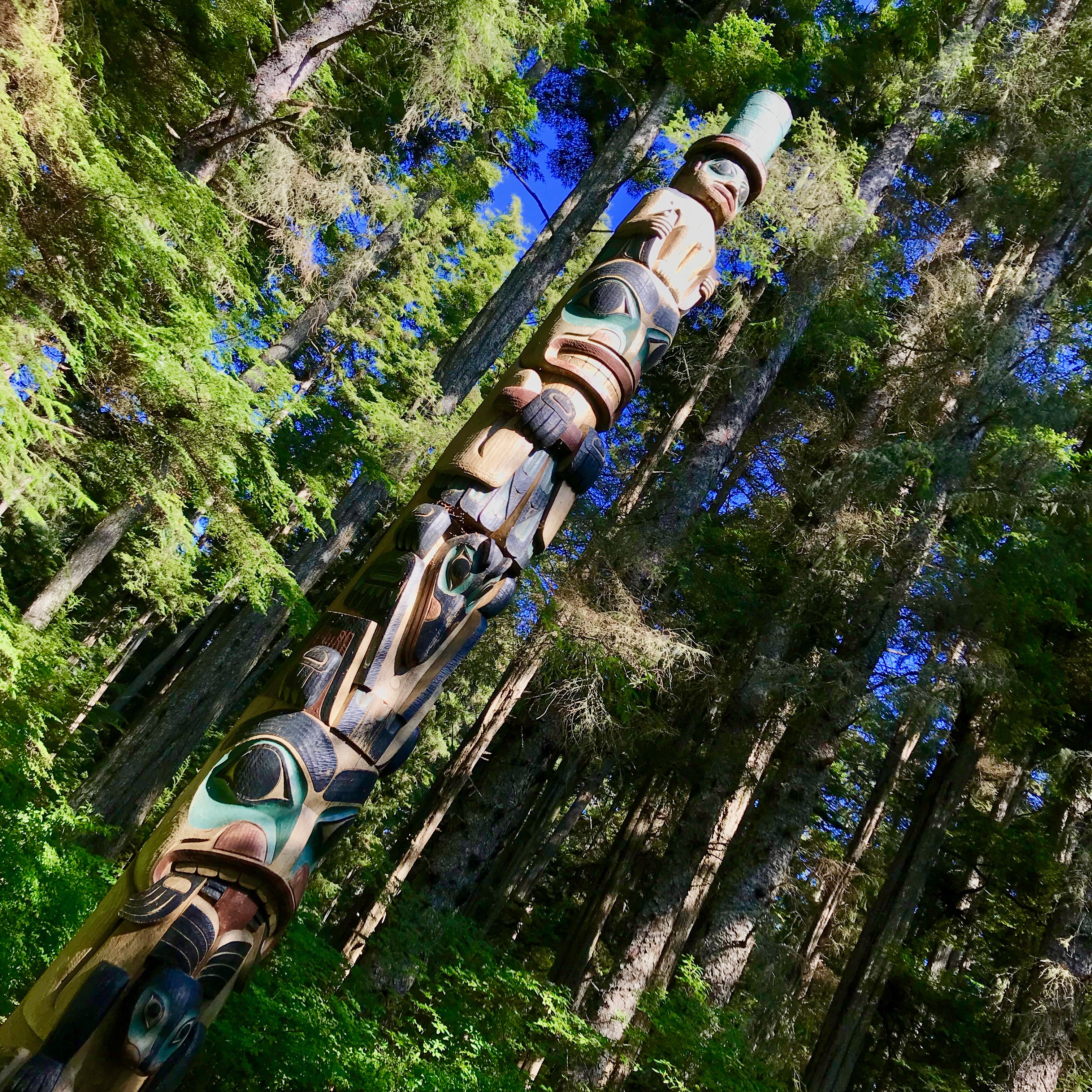 As if hiding deep in the green, the totem poles slowly appear along the forest walk, telling their particular story to the world.  Sitka, Alaska.
