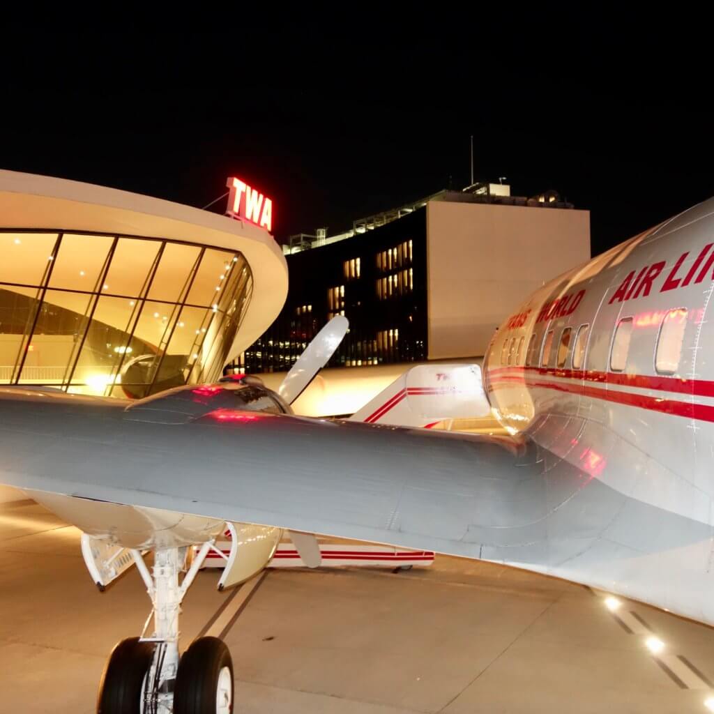 A vintage Lockheed Super Constellation flown by TWA in 1962 when the Historic Eero Saarinen JFK Airport Terminal was completed. This aircraft is now displayed outside the TWA Hotel and operates as a full cocktail lounge inside the fuselage.