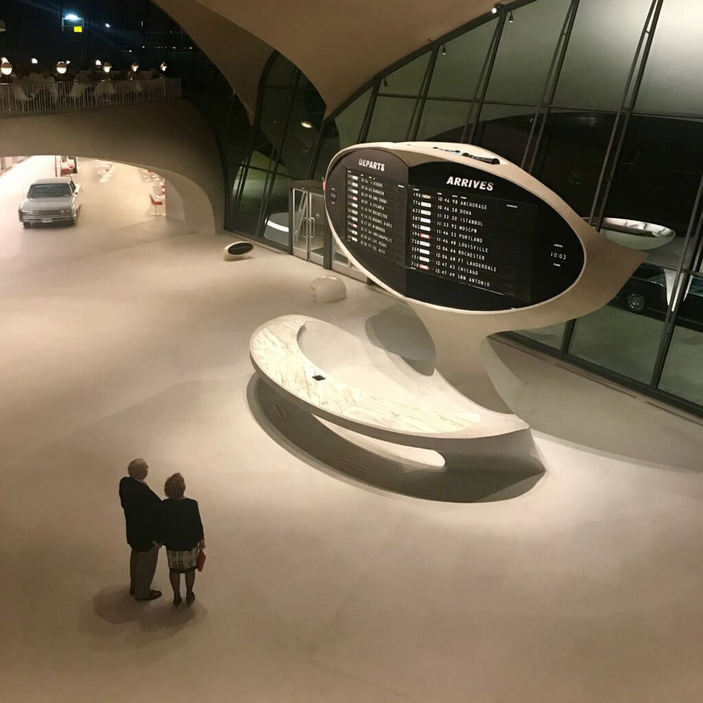 A couple views the iconic flight display in the entrance to the historic Eero Saarinen JFK Airport Terminal completed in 1962 for TWA.