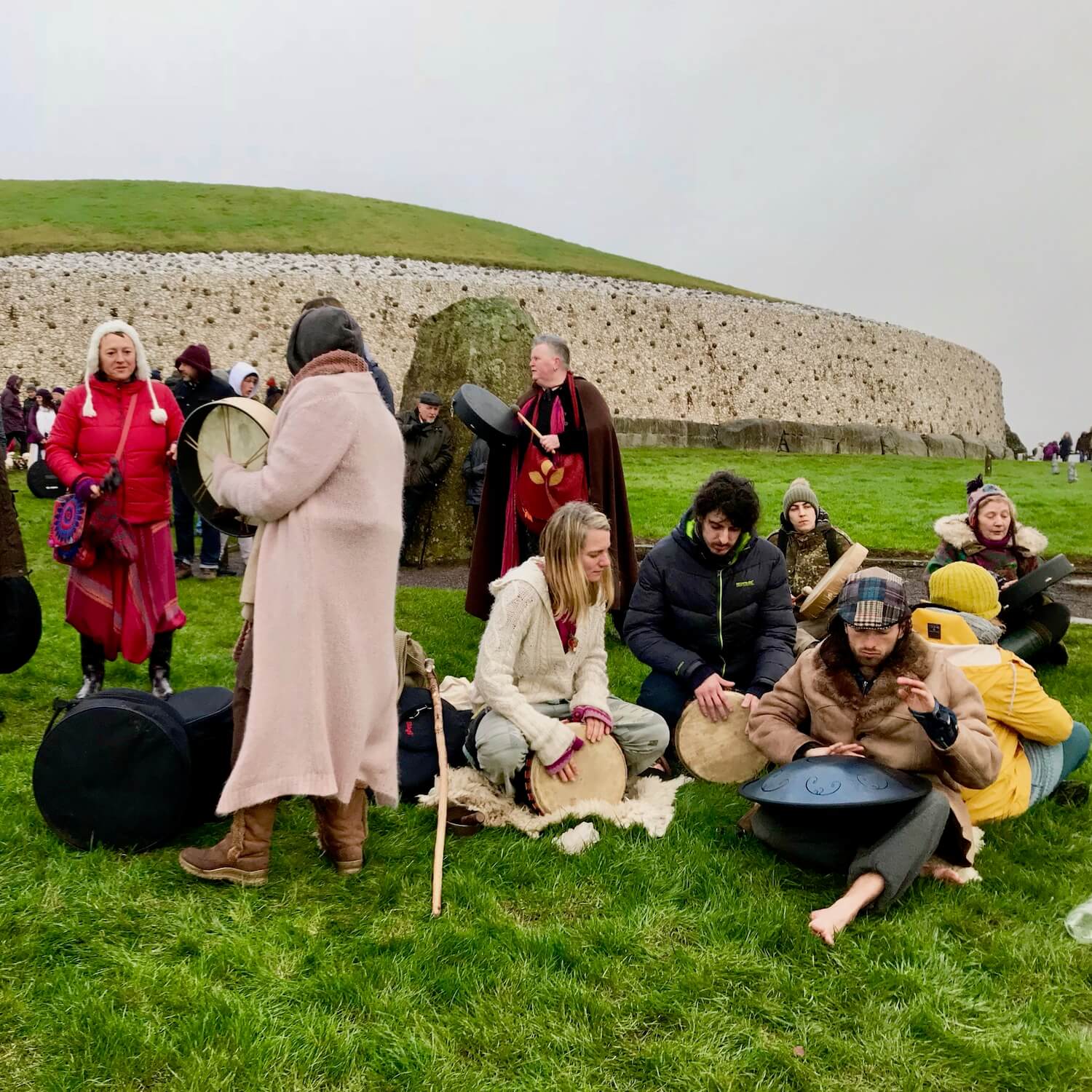 Newgrange Ireland winter solstice celebration as drummers reviving Celtic traditions strike their instruments on the grassy lawn in front of the entrance to the ancient hill on the shortest day of 2018