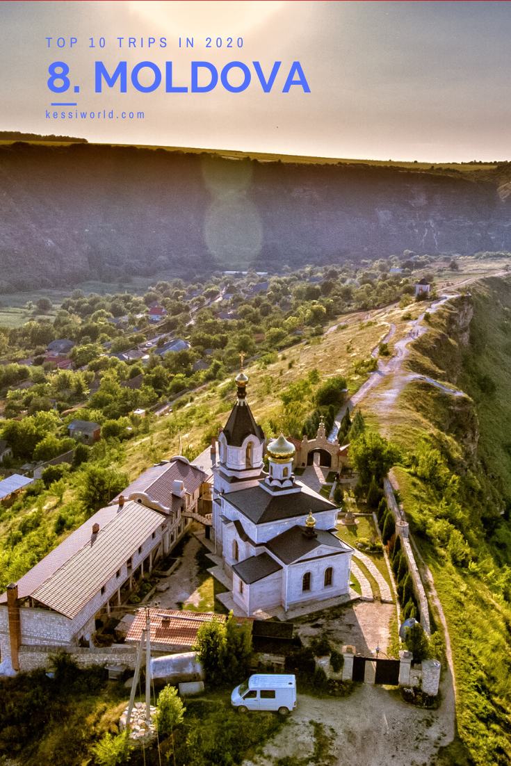 Of all the items on the 2020 global wish list, I know the least about Moldova, which is shown here with a orthodox church alone in a valley of bushy green trees and a few winding roads. In the background there is a ridge that leads to a large cliff.