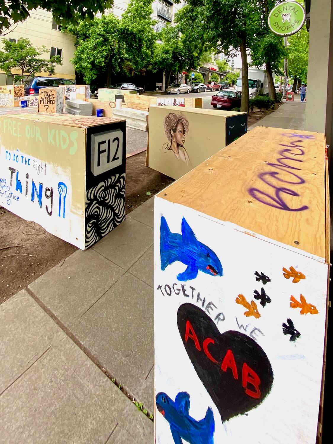An array of traffic dividers are covered with plywood and painted with various messages about kids and acceptance. This area is on one side of the Capitol Hill protest zone in support of Black Lives Matter movement in Seattle.