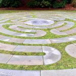 A maze made of stones wraps around the lawn creating a circular shape overall.