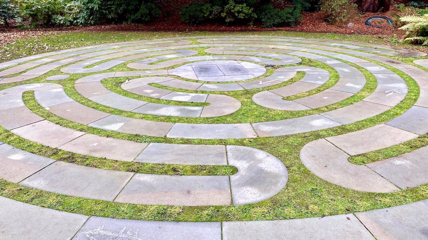 A maze made of stones wraps around the lawn creating a circular shape overall.  