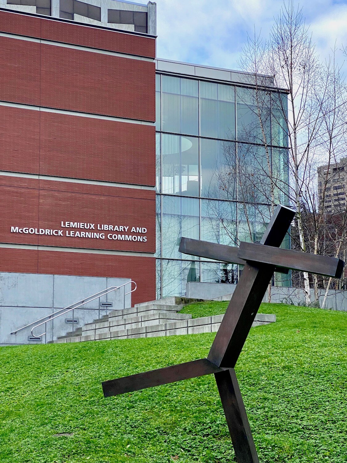 An animated rusted metal sculpture seems to frolic on the lawn in front of the library at Seattle University. 