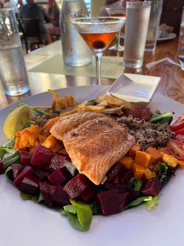 Eating seafood is a great thing to do in Brookings, Oregon and this meal features a delicious filet of pink salmon over a bed of beets and other delicious food.
