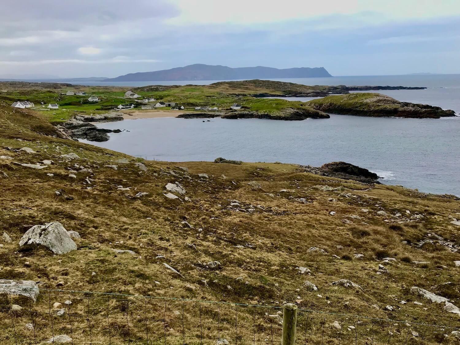 This view of Horn Head is from the vantage point of the Northern coast of Donegal and shows how rocky the coastline can be, while a sandy beach leads to an enclave of homes nestled between the rolling hills. 
