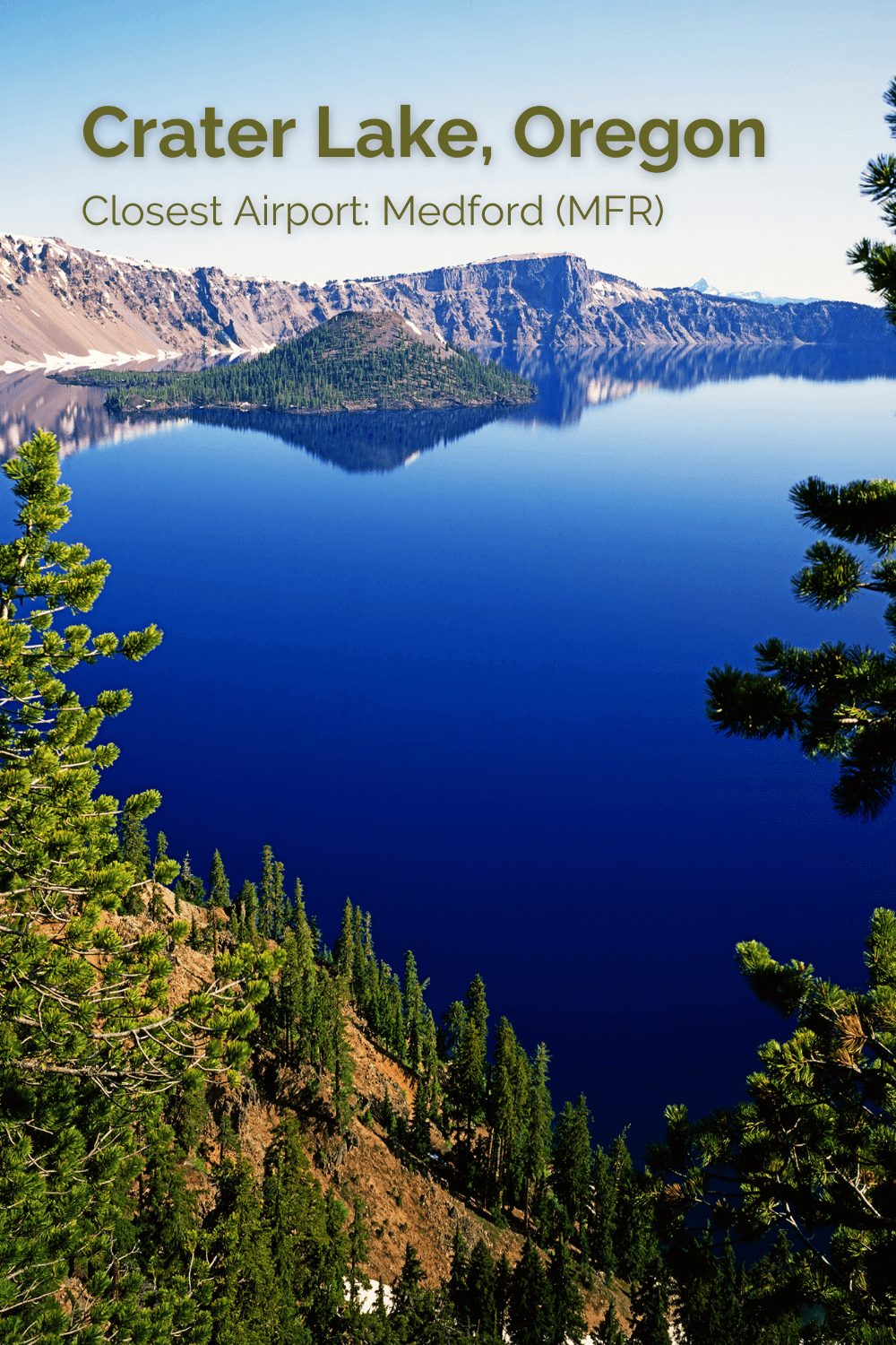 This photo depicts the rich blue water of Crater Lake in Oregon.  There is an island in the middle of the lake with a forest of green fir trees while the rocky ridge of the imploded volcano rises up to frame in this shot. 