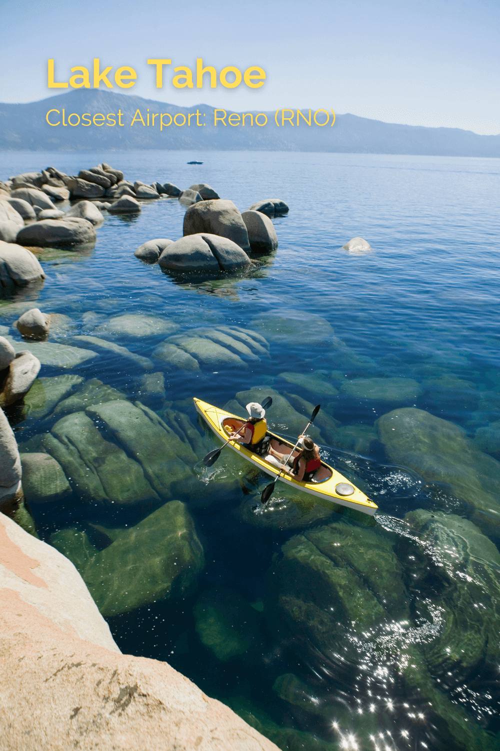 Photo of two kayakers paddling in a yellow kayak around Lake Tahoe.  The water is very clear and reveals large rounded boulders under the flowing water.  The other side of the lake is faintly visible under the blue sky. 