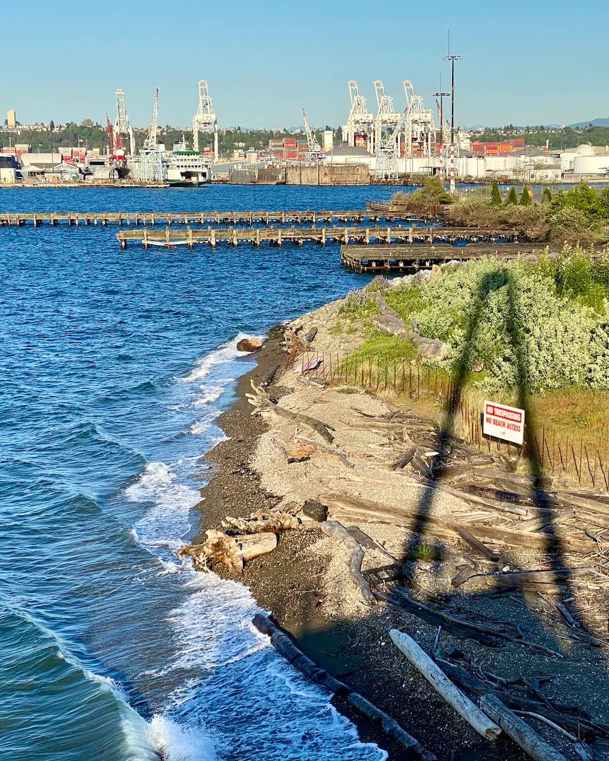 This view from Jack Block park in West Seattle shows waves crashing on a beach just beyond the industrial zone in Seattle.  