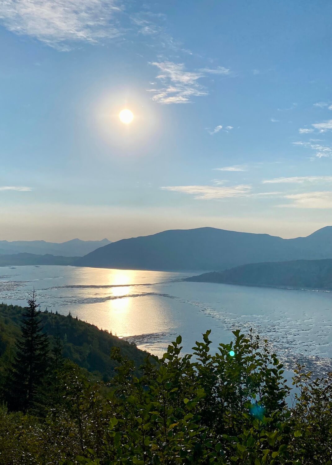 The sun begins to set over Spirit Lake. The water glows against the sun.