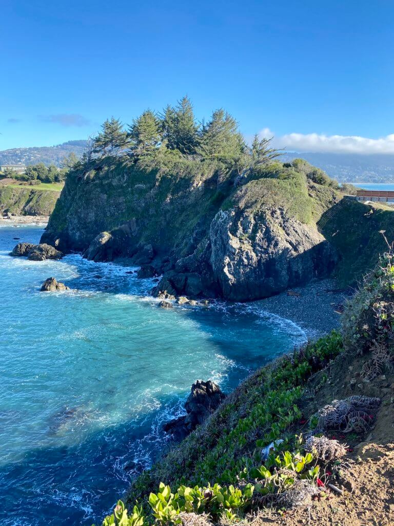 Exploring Chetco Point Park is a great thing to do in Brookings Oregon.  Here, the water gently crashes against the rocky beach surrounded by high cliffs covered with fir trees. 