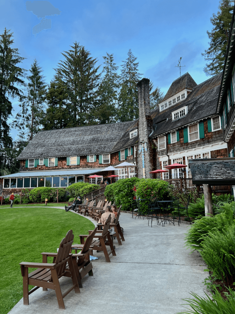 Lake Quinault Lodge is flashy in this sunny shot with blue sky and green fir trees framing in the impressive historic hotel.