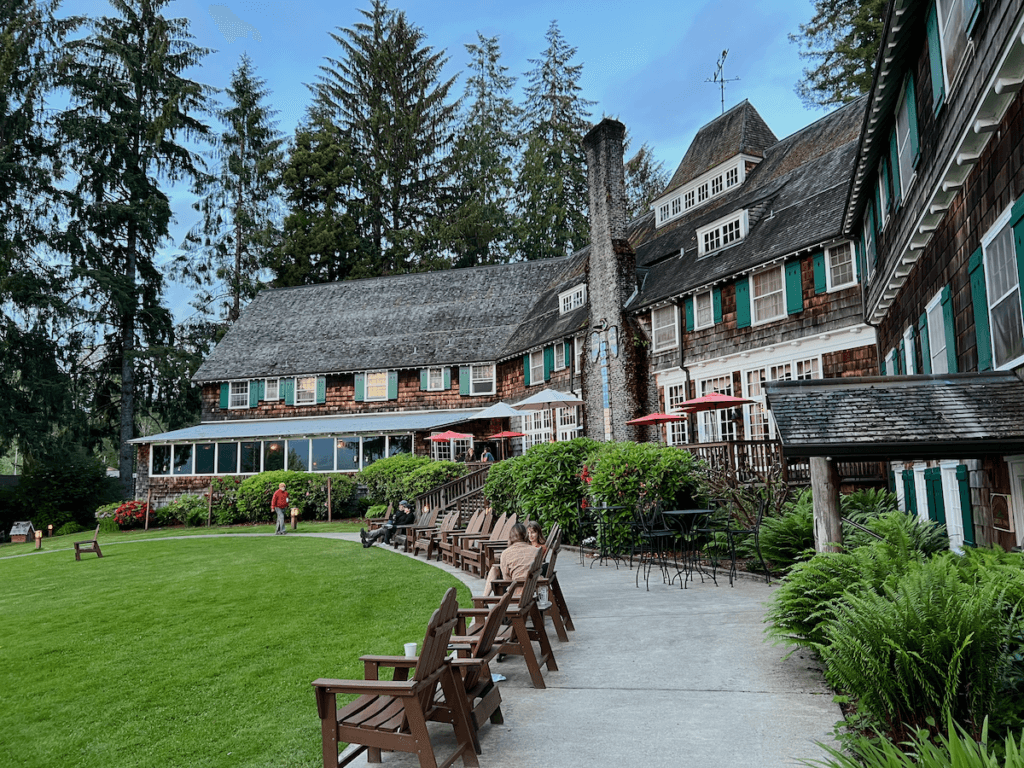 The impressive view of Lake Quinault Lodge shows the cedar shake siding and green shutters contrasting with the blue sky above.