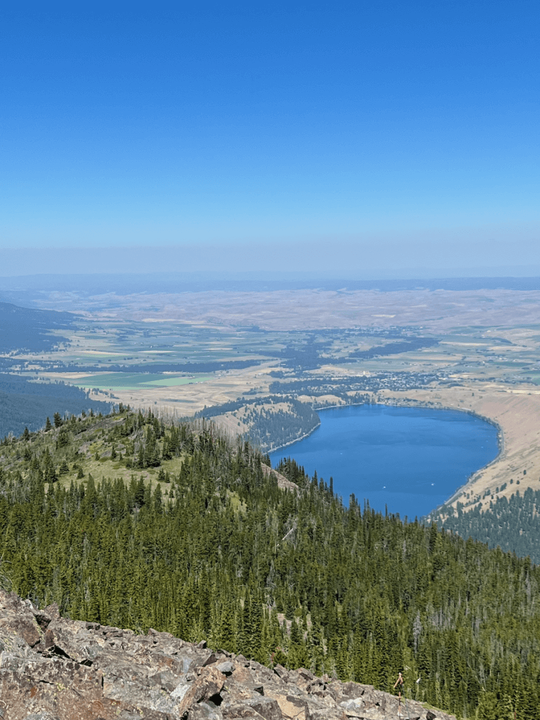 A sweeping view from the top of Howard Mountain, looking over the deep blue Wallowa Lake and the patchwork of crops around Joseph, Oregon.