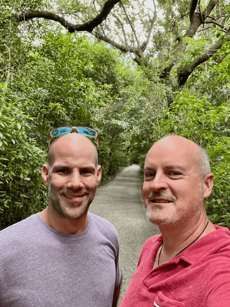 Matthew Kessi and Chad Lipton pose for a self in a jungle setting at a state park in Miami