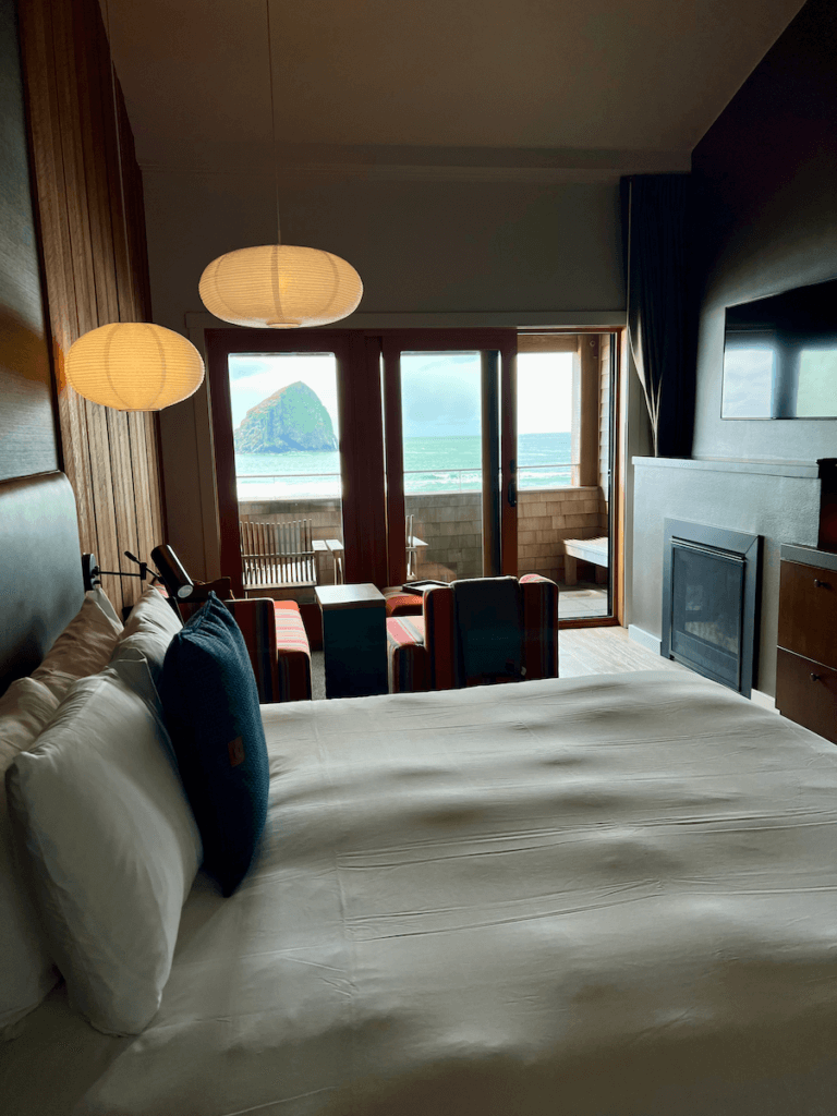 A greatest hit on the list of Oregon and washington hotels is the Headlands in Pacific City, on the Oregon Coast. This bed is situated in a hotel room with two nelson lamps and a beautiful view of Haystack Rock and the surf outside.