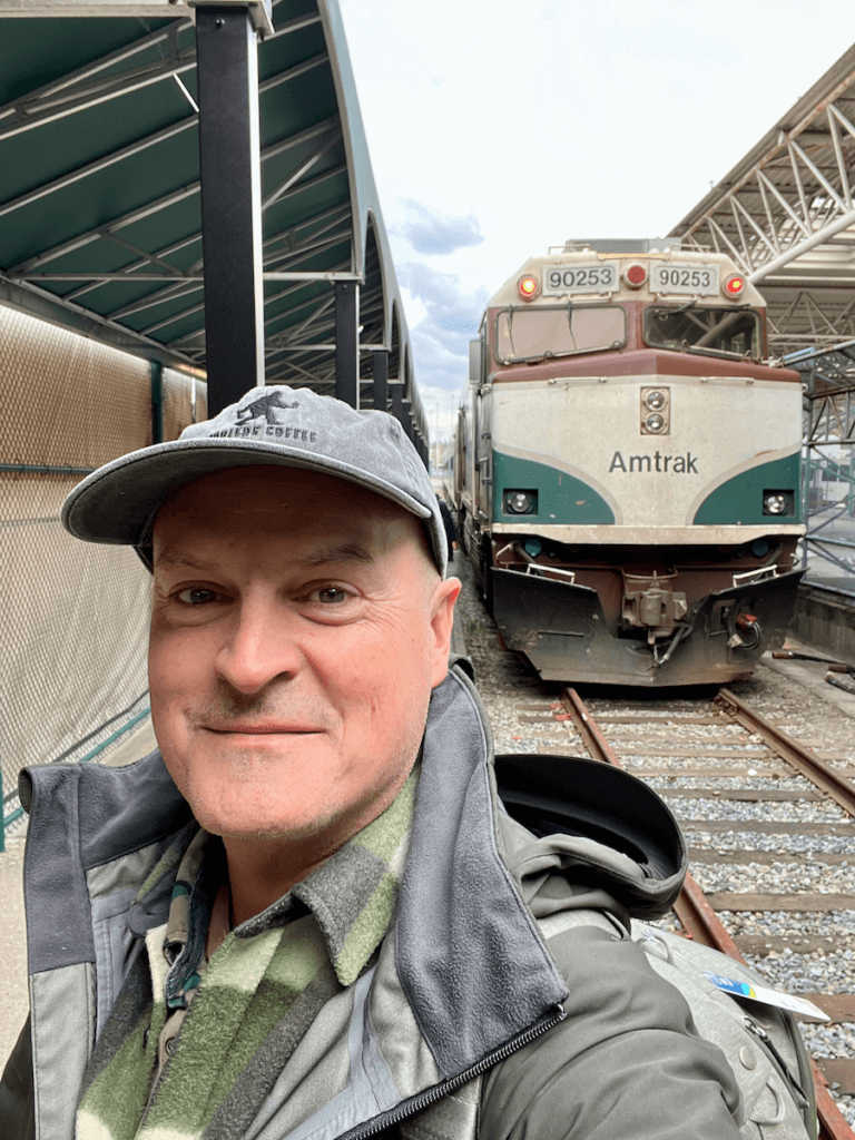 Matthew Kessi poses for a selfie in front of an Amtrak train engine in Vancouver Canada.