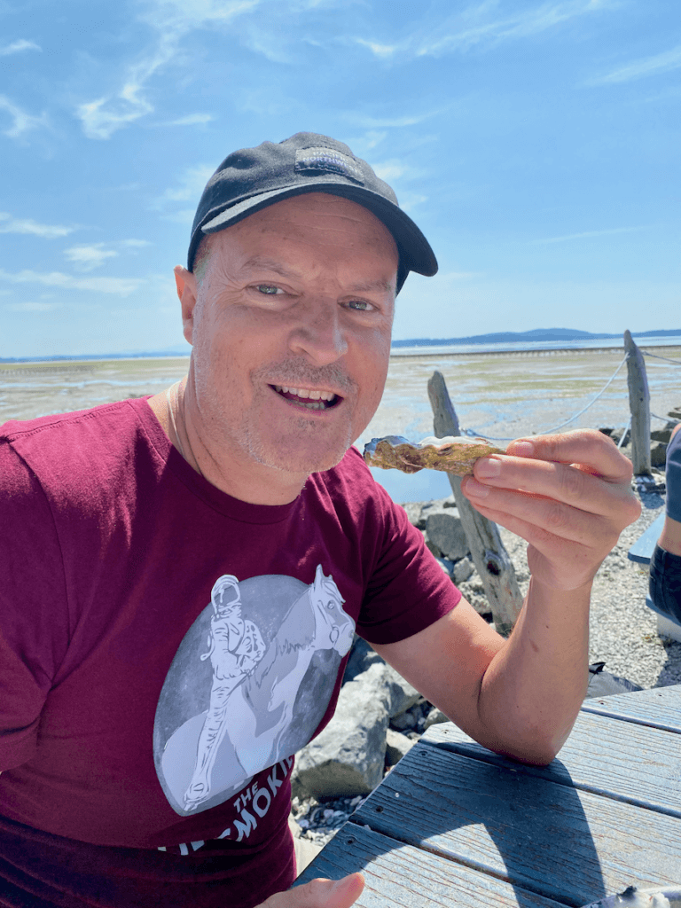 Matthew Kessi smiles as he gets ready to eat an oyster at Taylor Shellfish. He's stopping on the drive between Seattle and Vancouver to take in some Salish Sea scenery.