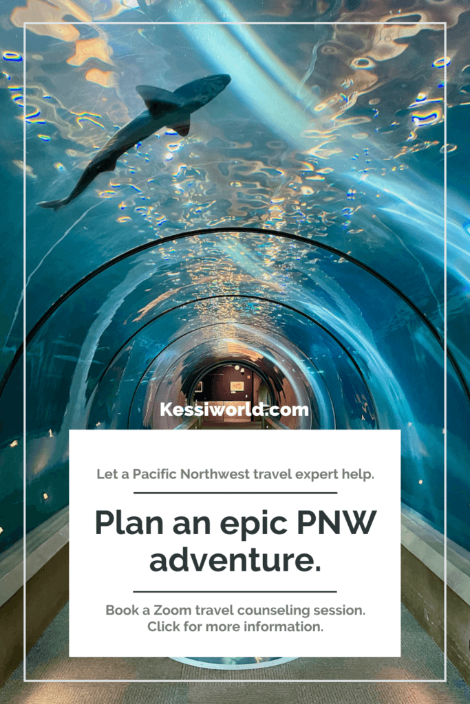 This tile shows a shark swimming overhead at Newport Aquarium. The text offers a pacific northwest expert to help you with travel planning by booking a zoom travel counseling session. The tunnel in this show is carpeted and the water above housing the sea life is various hues of blue.