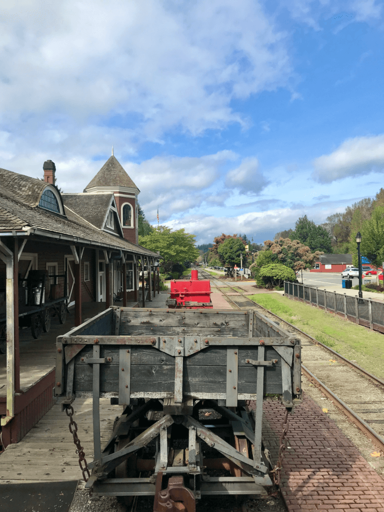 An old railroad flatbed sits on tracks next to a vintage railroad station in Snoqualmie, Washington, near Seattle.