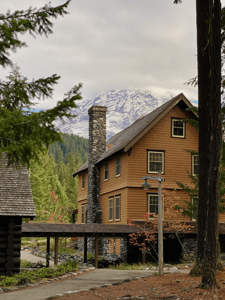 National Park Inn, on the way from Seattle to Mt. Rainier, is a great stop to see views of the mountain, like in this photograph. The four Storie building has painted brown shake siding under the prominent view of the great mountain.